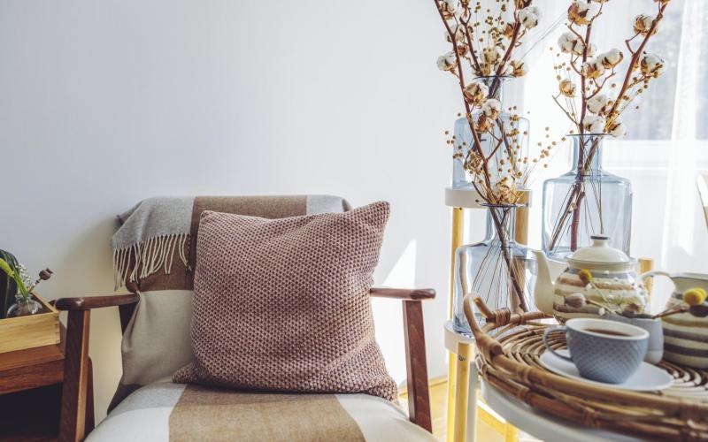 a chair and table with a vase of flowers on it